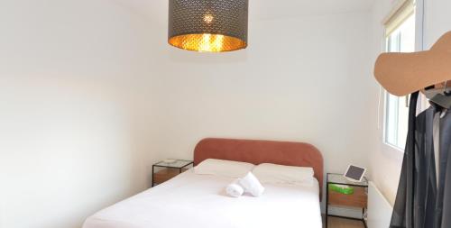 ein kleines Schlafzimmer mit einem Bett und einer Lampe in der Unterkunft Appart'Genevois in Villeurbanne