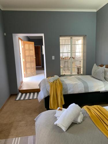 a bedroom with two beds and a door to a balcony at Vyfster - Old Jail in Britstown