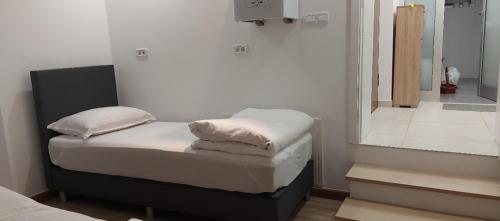 Un dormitorio pequeño con una cama y un espejo. en Apartman Dona, en Banja Luka