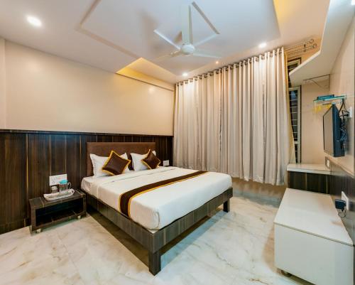 a hotel room with a bed and a window at Hotel Aatithya Satkar Near Mahalaxmi Temple in Kolhapur