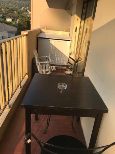 une table et deux chaises sur un balcon dans l'établissement Cannes studio de 24 M2 proche centre ville, au Cannet