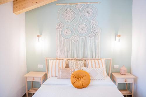 a bedroom with a bed with a orange pillow on it at Moneglia in Piazza in Moneglia