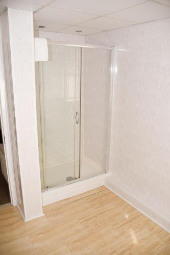 a shower stall in a room with a wooden floor at Stuart hotel in Blackpool