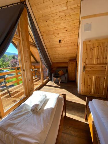 a bedroom with two beds and a large window at Jedlina - naturalny dom z bali jodłowych in Cisna