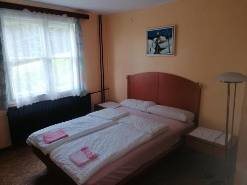 a bedroom with a bed with pink towels on it at Smučarska koča in Kotlje