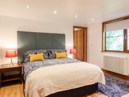 um quarto com uma cama grande e almofadas amarelas em Willow Cottage em Dartford