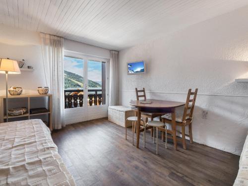 a bedroom with a table and chairs and a window at Studio Courchevel 1650, 1 pièce, 3 personnes - FR-1-563-62 in Courchevel