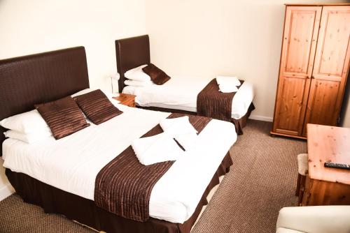 a room with two beds and a cabinet at Stuart hotel in Blackpool