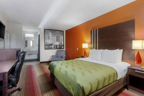 a hotel room with a bed and a desk at Quality Inn Columbus-East in Columbus