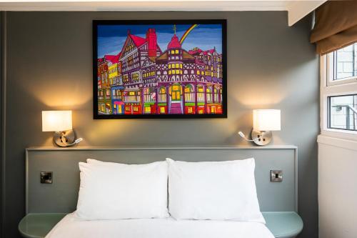 a bedroom with a painting on the wall above a bed at Mercure Chester Abbots Well Hotel in Chester