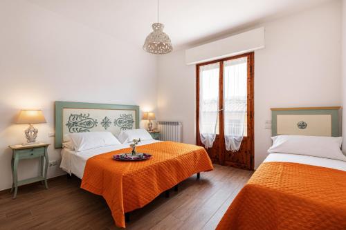 a bedroom with two beds and a table with orange sheets at Casa Vacanze Alessandro 2 in Greve in Chianti