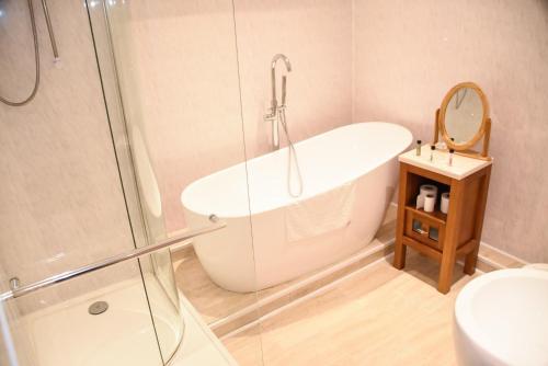 a bathroom with a tub and a shower and a sink at Stuart hotel in Blackpool