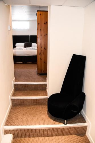 a black chair in a room with a bedroom at Stuart hotel in Blackpool