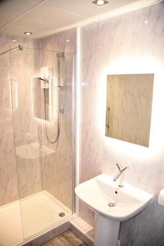 a bathroom with a sink and a shower at Stuart hotel in Blackpool