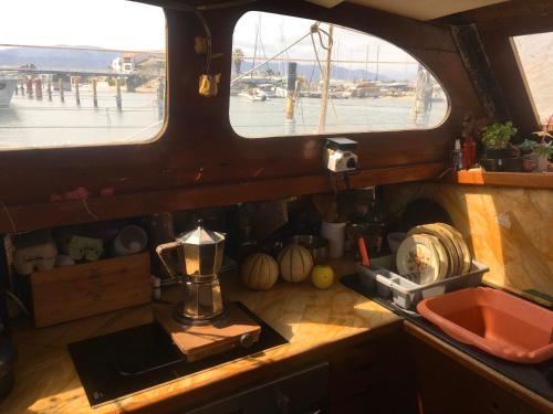 a kitchen with a counter and two windows in a boat at Eco-responsible stay on the historical sailing boat of the Gaiarta Project - come and stay with our crew and get the whole boat experience in Saint-Cyprien