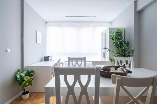 a dining room with a white table and chairs at Midtown Rosalia in Vigo
