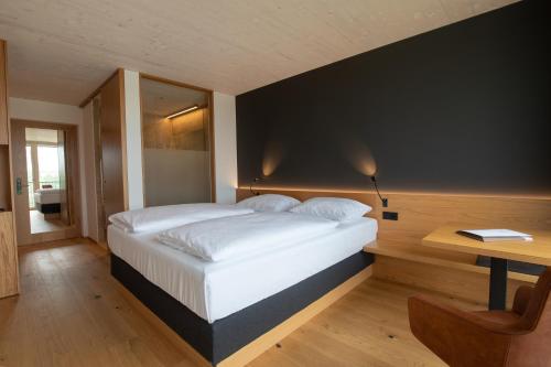 een slaapkamer met een groot wit bed en een bureau bij 2ND HOME HOTEL in Nördlingen