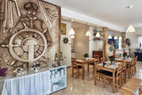 a restaurant with a wall mural of a man with an anchor at Willa Kapitańska i Willa Marynarska in Łeba