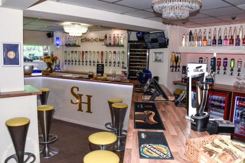 a bar with yellow stools in front of a counter at Stuart hotel in Blackpool
