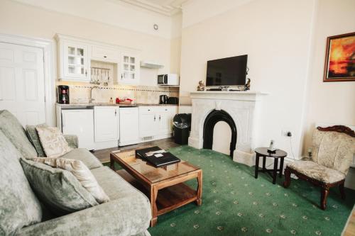 a living room with a couch and a fireplace at The Town House in Douglas