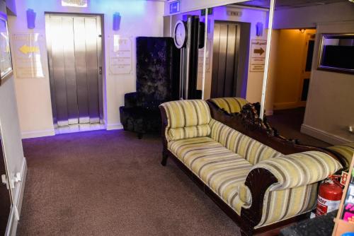 a living room with a couch and a tv at Stuart hotel in Blackpool