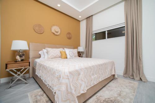 a bedroom with a large bed and a window at Luxury 1 bed apartment near Seven Mile Beach at The Grove - Villa Gypsy Soul in Upper Land