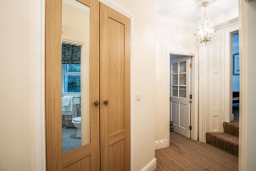 a hallway with a wooden door and a toilet at The Town House in Douglas