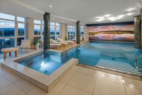 a large swimming pool in a house with a painting at Hôtel restaurant Spa de l'Abbaye in Grande Riviere