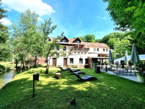 a resort with a park with slides in the grass at Restaurant Niedmühle Land & Genuss Hotel in Rehlingen-Siersburg