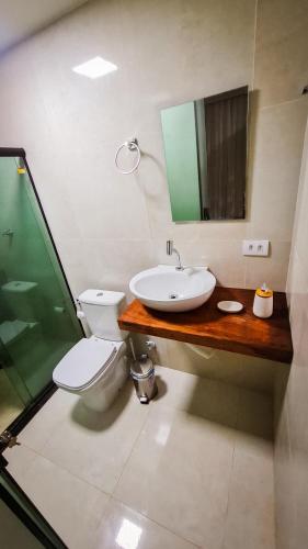 a bathroom with a sink and a toilet and a mirror at Flat Noronha Dreams in Fernando de Noronha