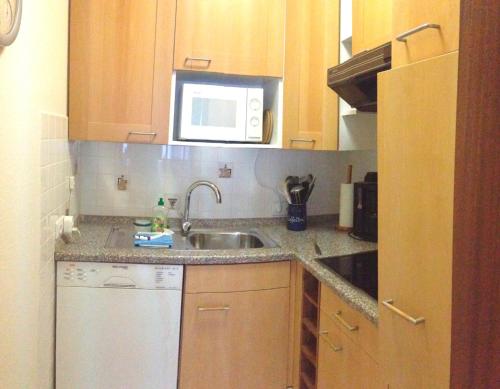 a small kitchen with a sink and a microwave at Wohnung Nr 2 in Haffkrug