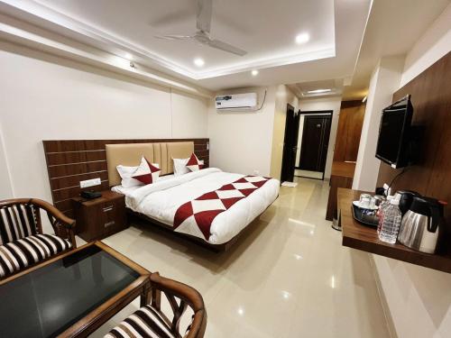 a bedroom with a bed and a couch and a television at Hotel MK Grand in Varanasi