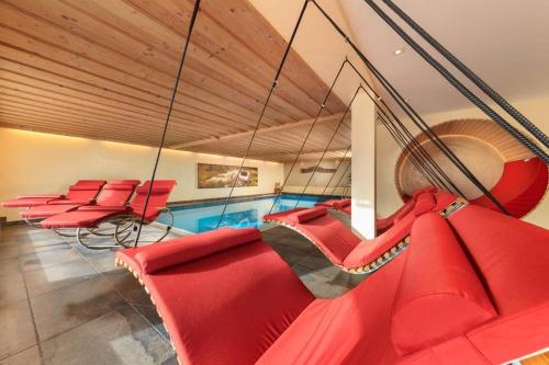 a group of red chairs in a room at Hotel Natur-Landhaus Krone in Maierhöfen