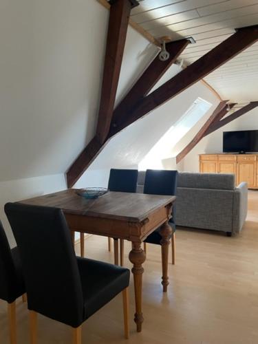 een kamer met een tafel en een bank op zolder bij Landhaus Lindenbusch in Weseke
