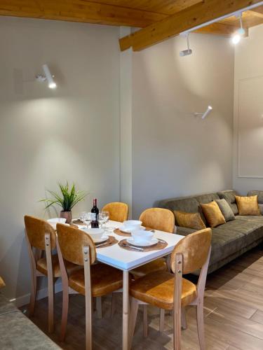 a dining room with a table and chairs and a couch at Arial Penthouse Suites in Vlorë