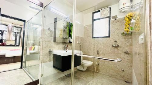 a bathroom with a shower and a toilet and a sink at Olive Service Apartments - Vaishali Nagar in Jaipur