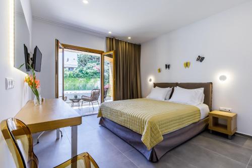 a hotel room with a bed and a desk and a window at Olia Green Residence in Skopelos Town