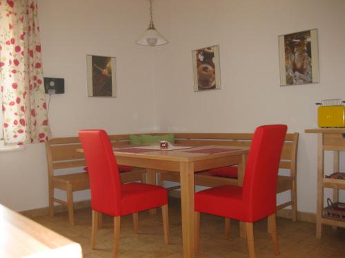 a dining room table and chairs with red chairs at Appartement St. Leonhard in Graz