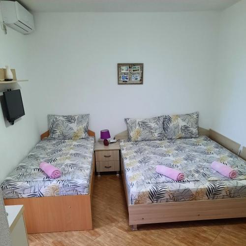- deux lits assis l'un à côté de l'autre dans une pièce dans l'établissement Apartmani Milica Dojran, à Dojran