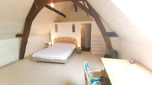 a bedroom with a bed in an attic at La Maison de Louise Chinon #chateaux #vignobles in Chinon