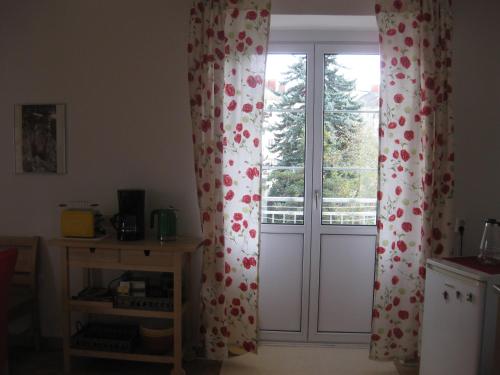 a window with curtains with red and white flowers at Appartement St. Leonhard in Graz