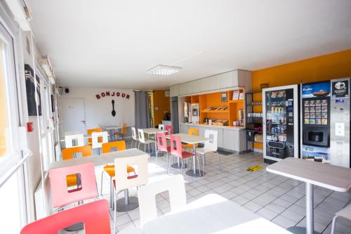 un restaurante con mesas y sillas coloridas en una cafetería en Première Classe Cherbourg - Tourlaville, en Cherbourg-en-Cotentin