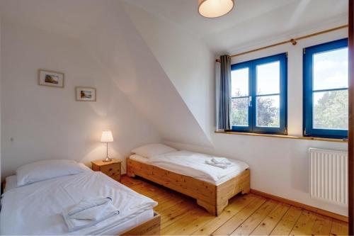 two beds in a room with two windows at 3-Raum Apartment bis 6 Pers 42 in Rankwitz