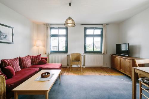 uma sala de estar com um sofá vermelho e uma televisão em 3-Raum Familienapartment bis 4 Pers 53 em Rankwitz