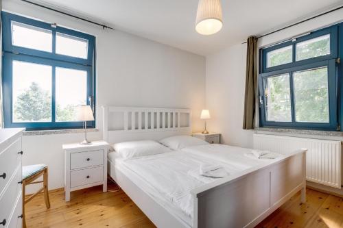 1 dormitorio con 1 cama blanca y 2 ventanas en 3-Raum Familienapartment bis 4 Pers 53, en Rankwitz