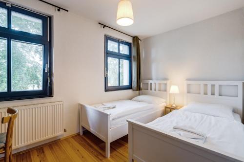 two beds in a room with two windows at 3-Raum Familienapartment bis 4 Pers 53 in Rankwitz