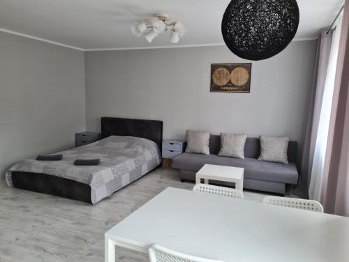 een woonkamer met een bed en een bank bij Central Moon in Daugavpils