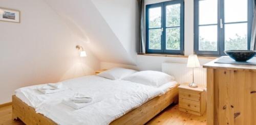 2-Raum Apartment bis 4 Pers 32 في Rankwitz: غرفة نوم مع سرير في غرفة مع نوافذ