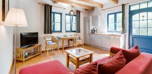 sala de estar con sofá rojo y mesa en 2-Raum Apartment bis 4 Pers 13 en Rankwitz