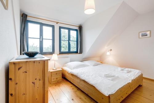 Schlafzimmer mit einem Holzbett mit weißer Bettwäsche in der Unterkunft 2-Raum Apartment bis 4 Pers 32 in Rankwitz